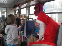 Der Nikolaus verteilt w&auml;hrend der Fahrt an die Kinder und Erzieherinnen des Patenkindergartens Geschenke.
